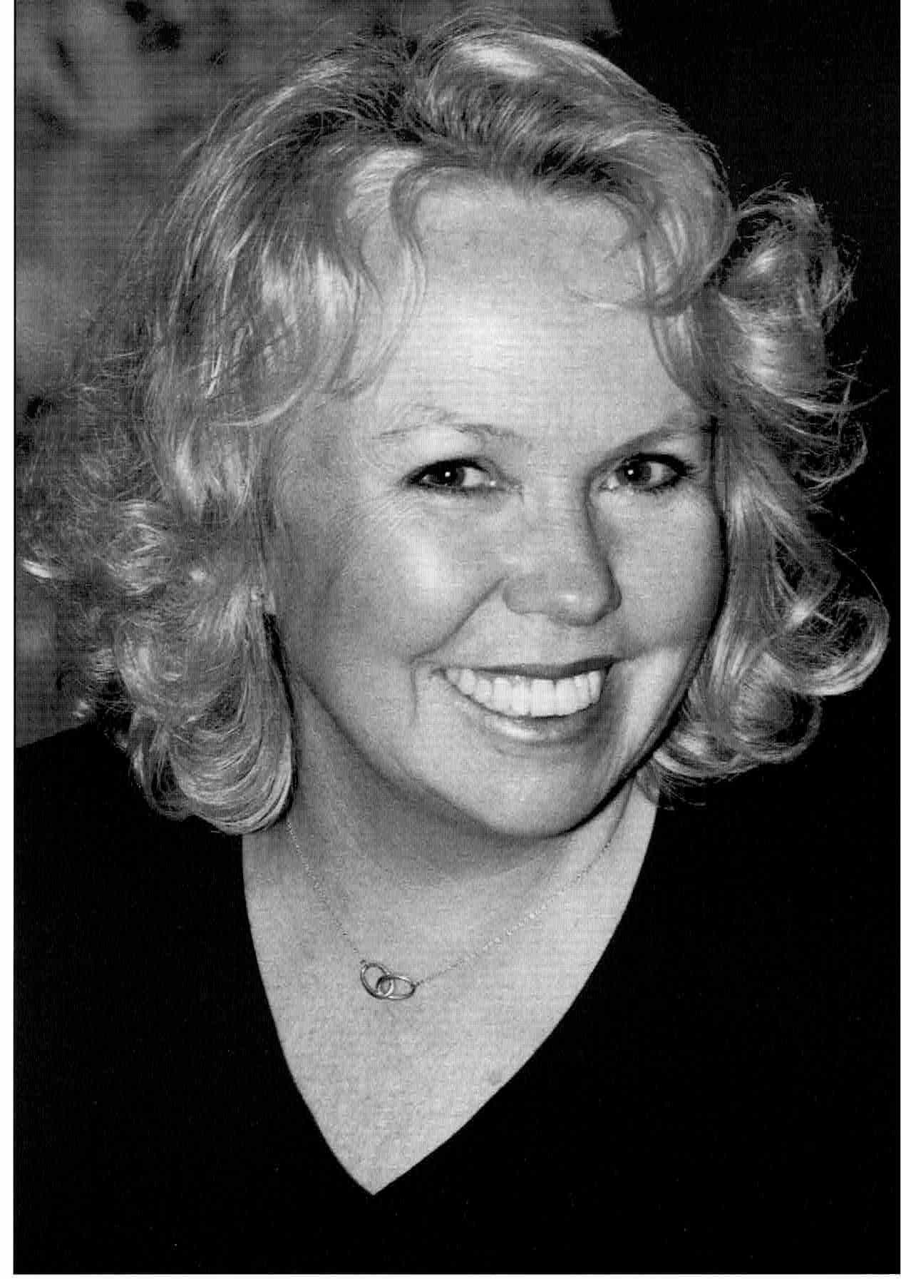 Smiling woman with short curly blonde hair