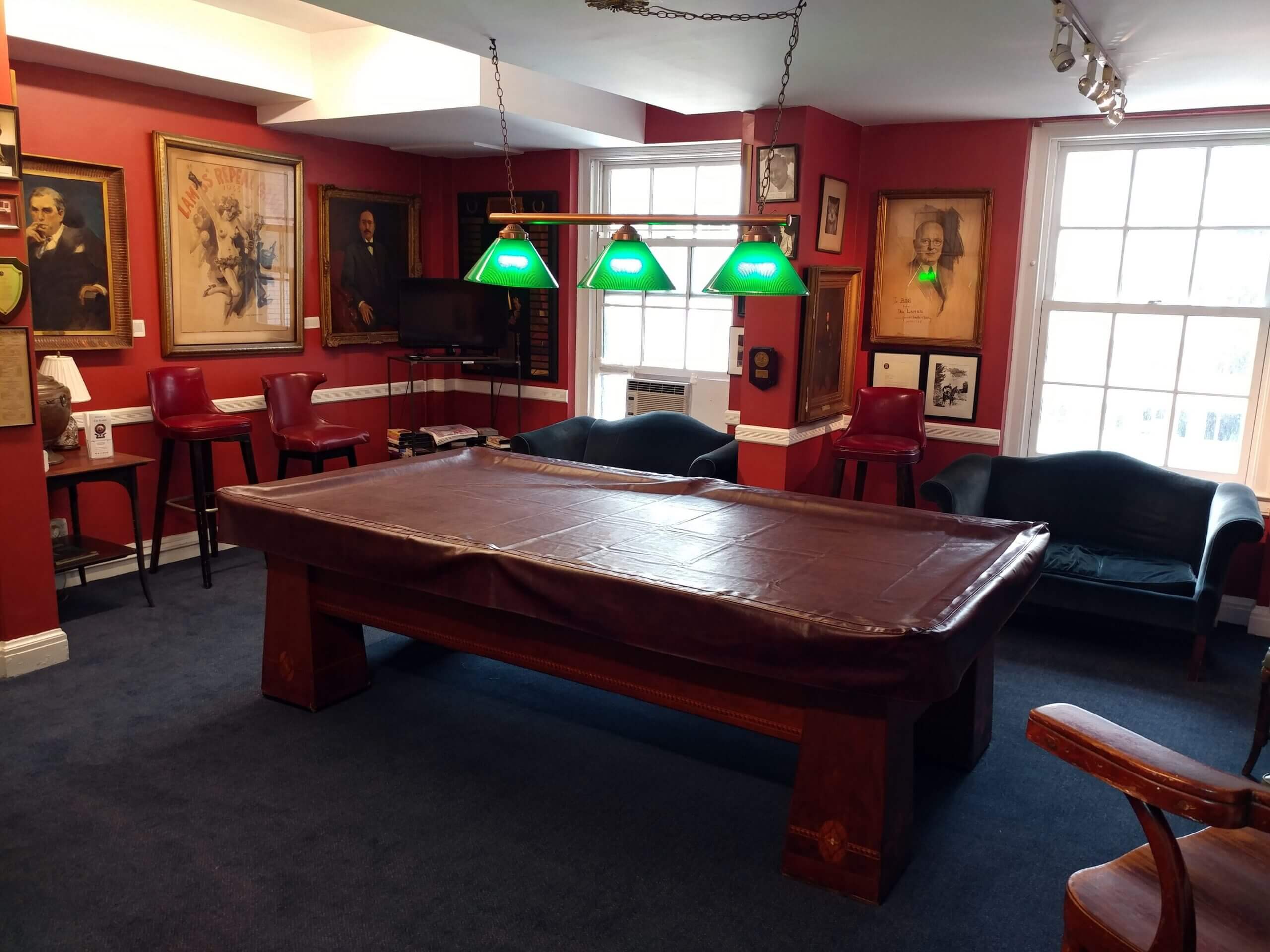 Vintage billiards room with portraits and sofas