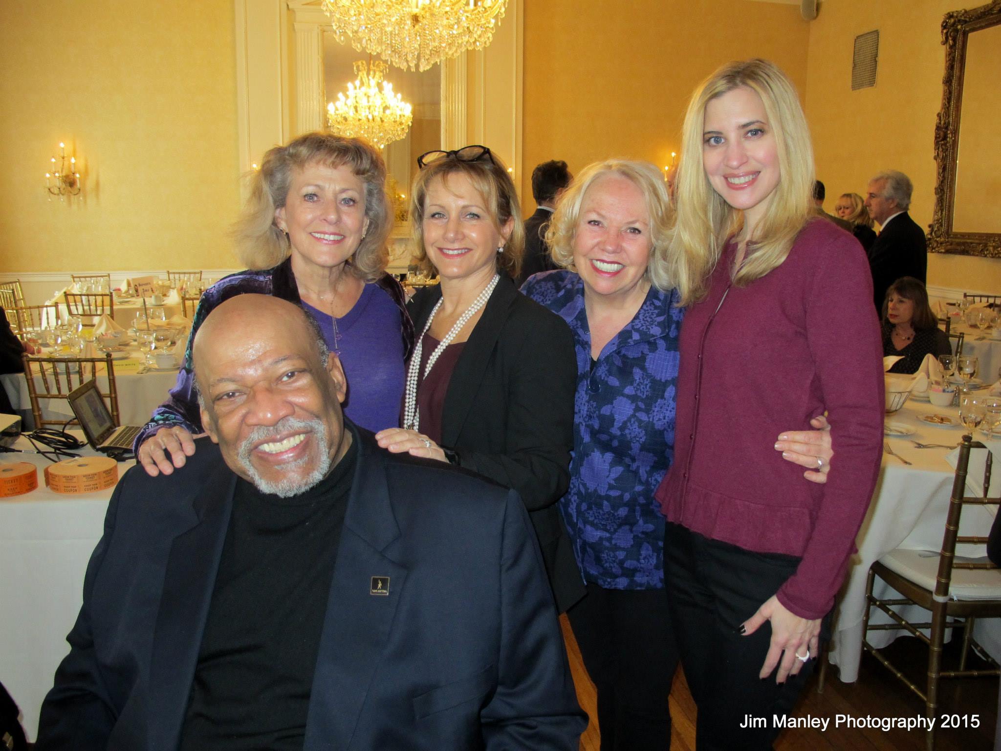 Five smiling guests at elegant chandelier banquet