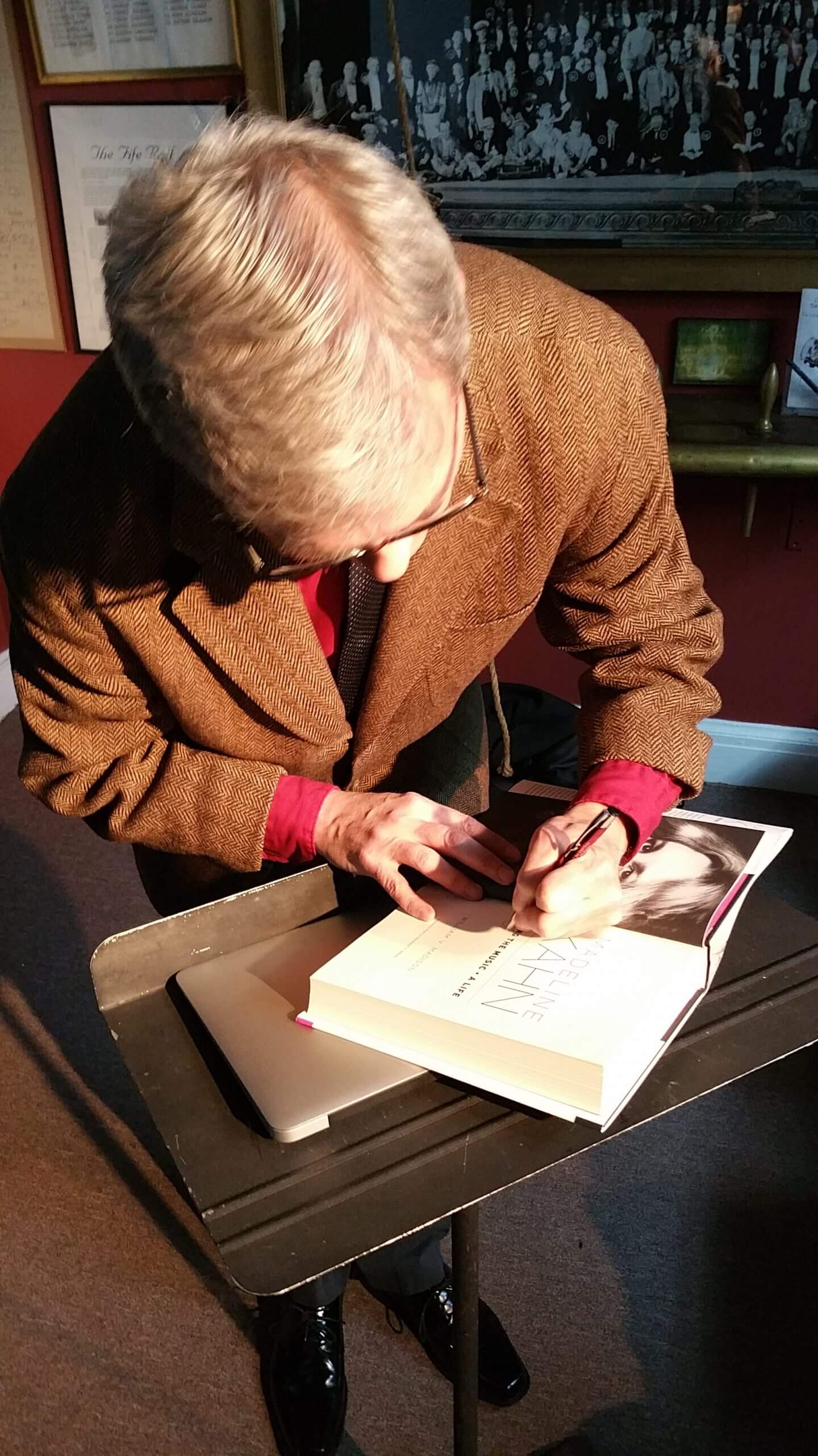 Book signing: older person at lectern