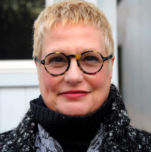 Smiling short-haired woman wearing round tortoiseshell glasses