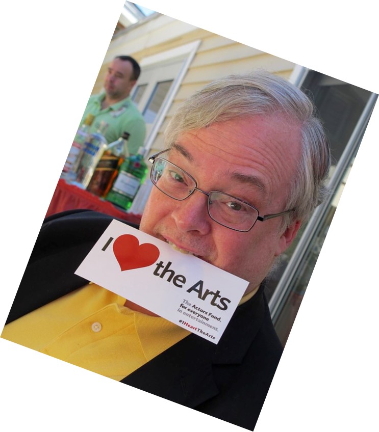 Smiling man biting "I ♥ the Arts" card