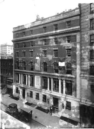 Historic six-story neoclassical building with flags