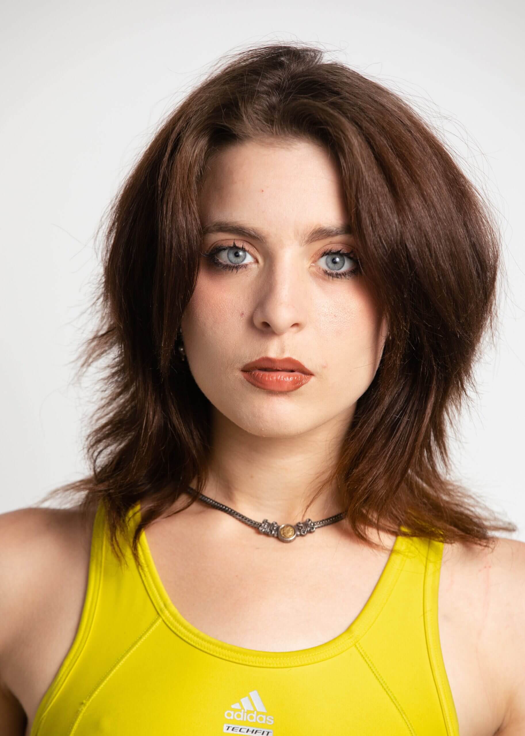 Woman with brown hair in yellow top.